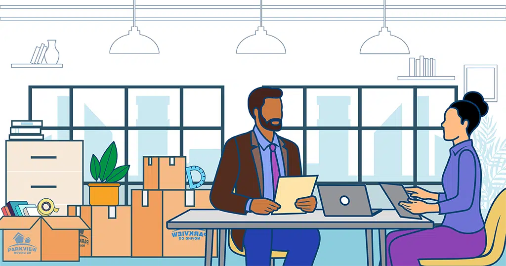 Office Relocation Tips – Moving Boxes and Office Setup Two employees in an office surrounded by moving boxes during an office relocation.